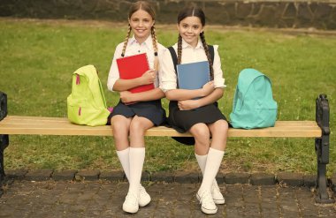 Birlikte daha iyi bir gelecek. Okul çocukları parktaki bankta otururlar. Mutlu çocuklar okula dönsün. Çocukluk eğitimi. Resmi moda. Öğrenci üniforması. Başla. 20 Kasım. Uluslararası Çocuk Günü