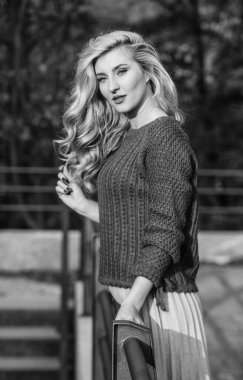 Sonsuza kadar burada kalırdım. Uzun sarı saçlı kız şehir yürüyüşü. Sonbahar kadını kıvırcık saçlı. Kadın güzeli. Etek ve süveter giyen kız. Pileli trend. Haidresser ve makyaj. Sonbahar moda sezonu