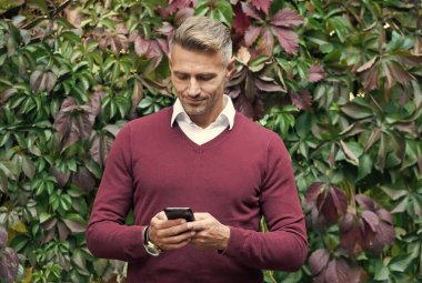 Gülümseyen adam akıllı telefonda mesaj yazıyor, iletişim.