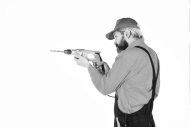 Duvarı delmek için taş ustası olmak lazım. Beyaz arka planı delinmiş şapkalı bir adam. Tamirci delik açıyor. Güvenlik önlemleri. Sondaj konsepti. Perforatör ve ısırık. Güçlü matkap. Matkap al