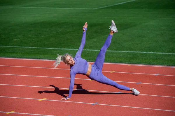 Spor salonundaki atletik kadın stadyumda geriniyor, yoga yapıyor. — Stok fotoğraf