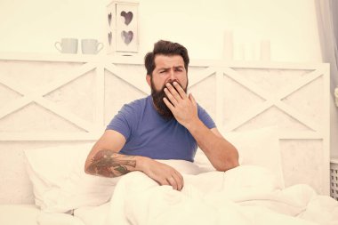 Daha çok erken. Sabah erkenden. Vücudunun ihtiyacı olan dinlenme için. Yatak sabahları çok rahat. Barışçıl yetişkin erkek dinleniyor. Sakallı adam yatakta esniyor. Uykulu adam yatak odasında rahatla.