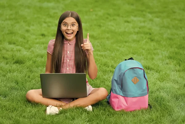 E 'perfetto. bambino giocare al gioco per computer. Torniamo a scuola. educazione online. giorno della conoscenza. lezione privata per bambini. idea blogging. ispirato ragazza seduta su erba verde con computer portatile. Avviare — Foto Stock