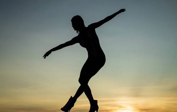 En graciös ballerina. sensuell kvinna siluett på himlen bakgrund. sensualitet — Stockfoto