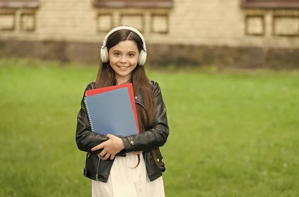 Wo Wissen auf moderne Trainingshilfen trifft. Glückliche Kinder tragen im Freien moderne Kopfhörer. Kleines Mädchen hört Musik. Modernes Leben. Neue Technologie. Modernes Lernen. Schule und Bildung — Stockfoto