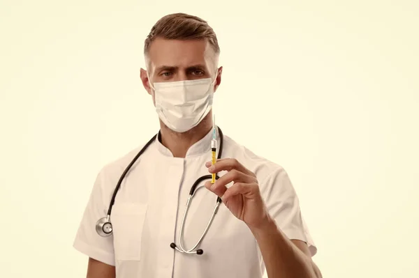 Медичний працівник у медичній масці для обличчя тримає шприц для лікування коїда-19 — стокове фото