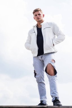 Beyaz şehir kıyafetleri içinde kendine güveni olan genç bir adam açık havada, moda.