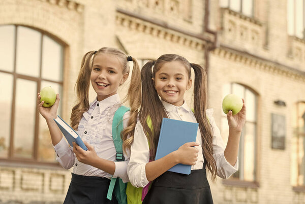 Учащиеся одноклассницы с рюкзаками, имеющие школьный обед, концепция здоровой жизни