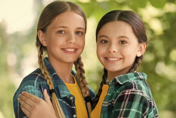 Ambiente de cuidado. Chicas felices en trenzas sonríen. Productos para el cuidado de la piel. Vacaciones de verano. Cosméticos para el cuidado del cabello. Salón de belleza. Cuidado de niños y cuidado de la salud pediátrica. Asistencia social —  Fotos de Stock