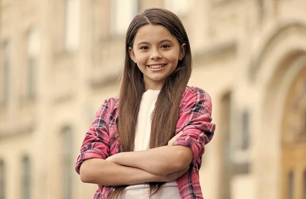 Lycklig flicka med långt hår i avslappnad stil hålla armarna korsade sommaren utomhus, förtroende — Stockfoto