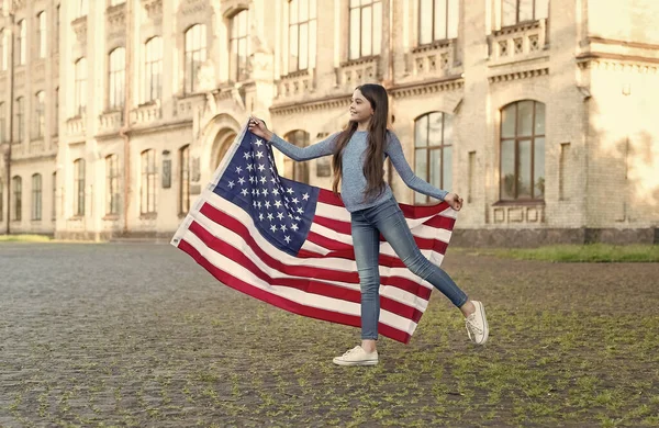 Bambina con bandiera americana all'aperto sfondo architettura, concetto di coscienza nazionale — Foto Stock