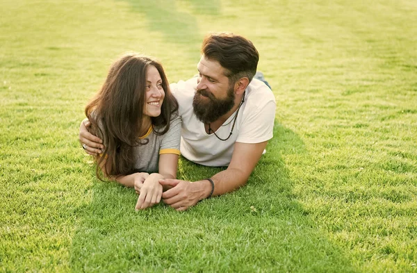 Feliz verano. Familia feliz relajarse en la hierba verde. Pareja enamorada citas en el paisaje natural. Felices vacaciones. Recreación familiar. Disfrutar y relajarse. Ser felices juntos — Foto de Stock