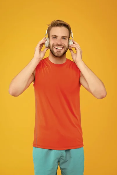 Get your best Solution. sport and music. quality of sound. innovative wireless device. workout. sportsman guy with ear stereo headphones. male fitness fashion. man in headset listen song for training — Stock Photo, Image
