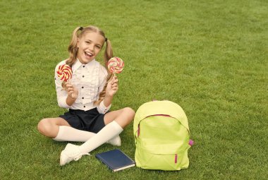 Öğrenmek için toplanın. Modern okul eğitimi. Mutlu çocukluk. Kitaplı genç kız. Küçük tatlı kız tatlı lolipop yiyor. Çocuklar için edebiyat eğitimi. belge diziniyle öğren. bilgi günü