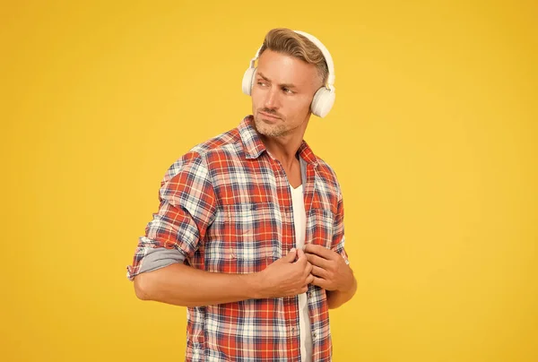 Hombre guapo botón camisa casual escuchar música en los auriculares modernos fondo amarillo, la vida moderna — Foto de Stock