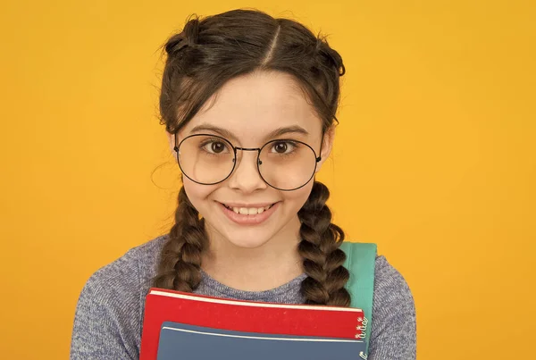 Smart beauty. Happy girl in pigtails yellow background. Hair salon. Beauty look of little child. Optical store. Opticians. Eye care. Corrective lenses. Keeping your beauty and sight fresh — Stock Photo, Image