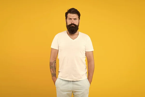 Brutale man met baard op gele achtergrond. mannelijke zomermode. Volwassen hipster heeft een perfecte snor. Een serieus uitziende man. mannelijke kapper zorg. krijgen stijl in kapperszaak. helder leven leven — Stockfoto