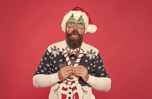 Sorprendido chico de santa en sombrero y gafas de fiesta como su suéter de invierno favorito divertirse en vacaciones de año nuevo, fiesta de año nuevo. —  Fotos de Stock