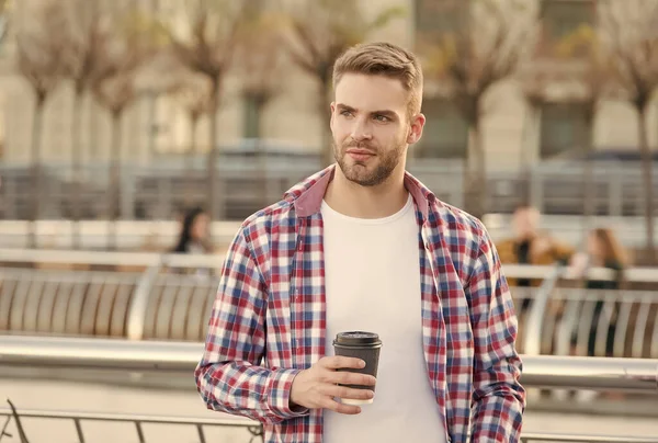 Ležérně oblečený muž pije ranní kávu z šálku. neoholený chlap se štětinami v městském stylu. moderní životní koncept. student pije čaj. pohledný mladý muž nosí kostkovanou košili. Čas snídaně — Stock fotografie