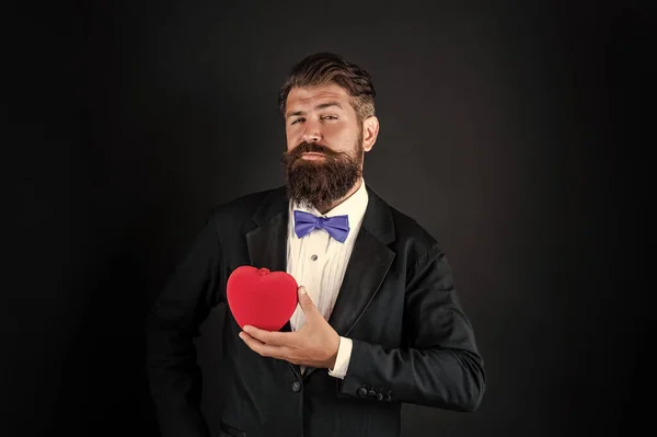 Confiante smoking homem com barba segurar romântico amor coração, feliz dia dos namorados — Fotografia de Stock