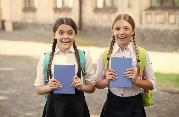 Glückliche Kinder in Schuluniformen halten Lernbücher im Freien, Wissen — Stockfoto