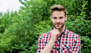 Tıraşsız yüzlü, şık saçlı, stili olan genç bir adam.