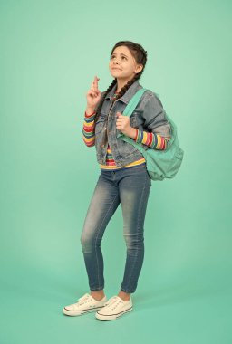 Batıl İnanç Günü 'ne meydan oku. Parmakları çapraz olan batıl inançlı bir çocuk. Küçük kız dilek mavi arka planı yapar. Şans dilemek için dua ediyorum. Batıl inançların kurbanı. 13. Cuma. Dünya batıl inançlarla dolu.