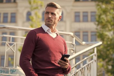 Kullanışlı bir uygulama. İş iletişimi. Çevrimiçi iletişim. Modern iletişim. İş adamı cep telefonunu tutar. Dışarıda telefonu olan yakışıklı bir adam. Taşınabilir yaşam tarzı. İnternet bağlantısı