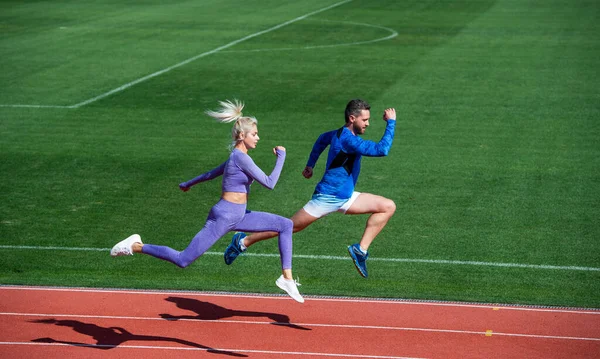 Desporto. velocidade da maratona. casal esporte correr rápido para ganhar. velocistas de fitness bem sucedidos. homem atlético e mulher sexy competir em sprint. Treinador masculino e feminino na pista de corrida do estádio. estilo de vida saudável — Fotografia de Stock