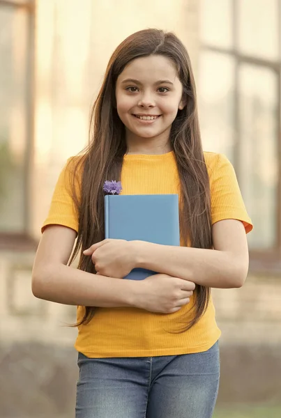 Szczęśliwe dziecko dziewczyna z powrotem do szkoły trzymać podręcznik, koncepcja wrzesień — Zdjęcie stockowe