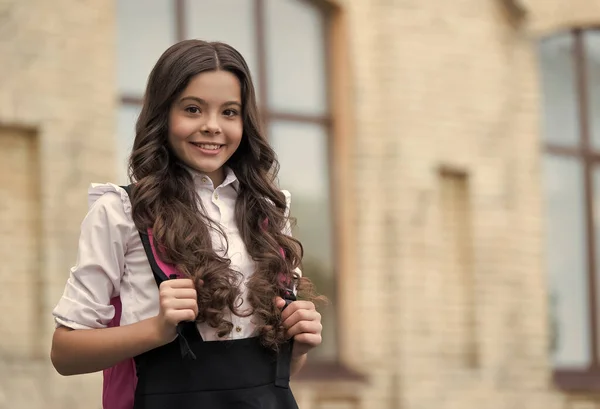 Šťastné dítě nosit dlouhé vlnité vlasy se zpět do školy vzhled ve škole, salon, kopírovací prostor — Stock fotografie