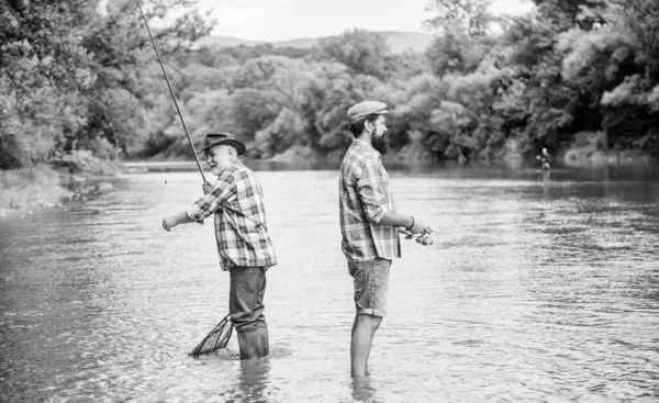 Get Hobby. hobby and sport activity. Trout bait. male friendship. family bonding. two happy fisherman with fishing rod and net. summer weekend. mature men fisher. father and son fishing — Stock Photo, Image
