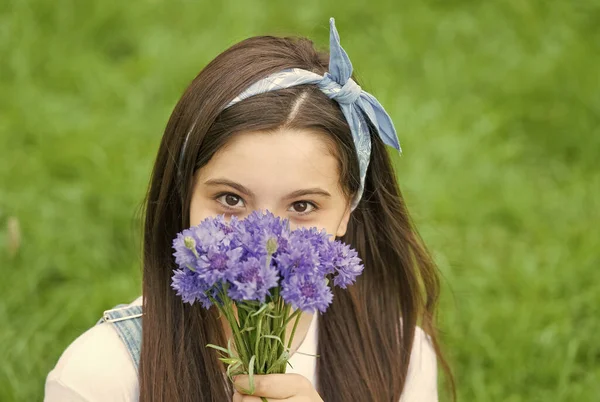 Flores de primavera trazem nova vida. Criança segura flores ao ar livre. Aparência de beleza de criança pequena. Loja de flores. Hora de verão. Celebração de férias. Flores e presentes para ela. Florescendo para a vida — Fotografia de Stock