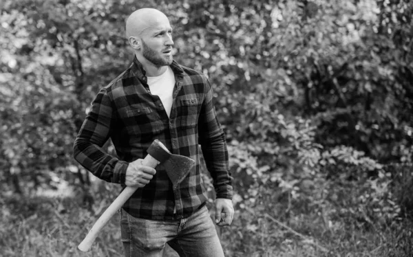 Brutal macho en el bosque. Potencia y fuerza. El leñador lleva hacha. Un leñador calvo. Cosecha leña. Caminata de vacaciones. Caminata en el bosque. Cuidado del bosque. Determinación del espíritu humano. Hombre camisa a cuadros uso hacha —  Fotos de Stock