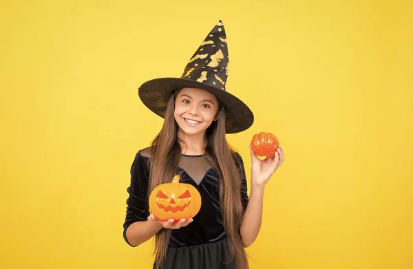 Happy witch kid with pumpkin jack o lantern wear costume of wizard on halloween party, halloween atribute — Stock Photo, Image