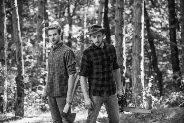 Genieten van de zomer samen. Zoek brandhout voor picknickkampvuur. Overleven in de wilde natuur. mens en natuur. Mannen wandelen in het bos. stropers in het bos. ontbossing. Ranger of stroperd. mens gebruik zaag en bijl — Stockfoto