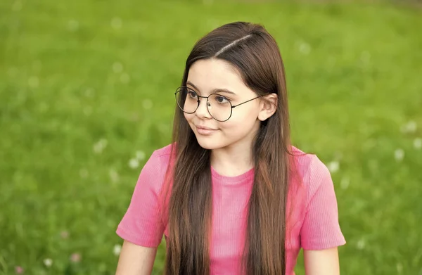 어린 소녀는 빈티지 테두리 안경을 쓰고 녹색 잔디 배경, 건강 관리 개념 — 스톡 사진