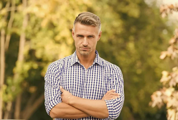 Well-groomed hair. casual guy in checkered shirt. male beauty standards. casual fashion for men. right barbershop makes your future. gray hair care. adult man with crossed hands. full of confidence — Stock Photo, Image