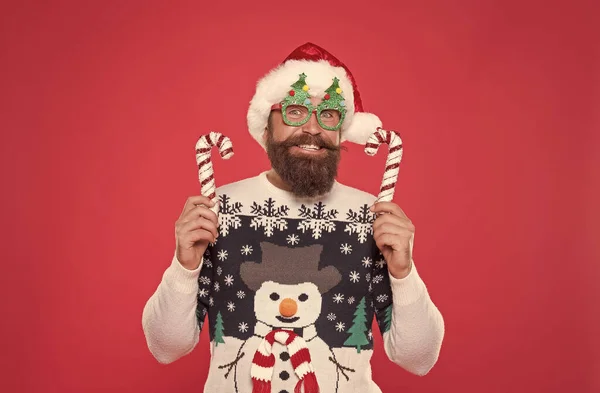 Noel Baba şapkalı ve parti gözlüklü adam en sevdiği kazak gibi Yeni yıl tatilinde eğleniyor, yeni yıl dekorasyonu yapıyor. — Stok fotoğraf