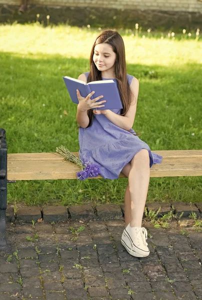Liten glad flicka läsa bok utomhus solig dag, intelligent hobby koncept — Stockfoto