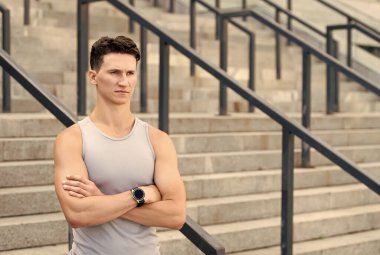 Kendinden emin genç adam eğitime hazır. Modern spor hayatı. Kişisel koçun. Profesyonel fitness eğitmeni. Yetenekli vücut geliştirici rejimini kontrol ediyor. kontrol altında eğitim