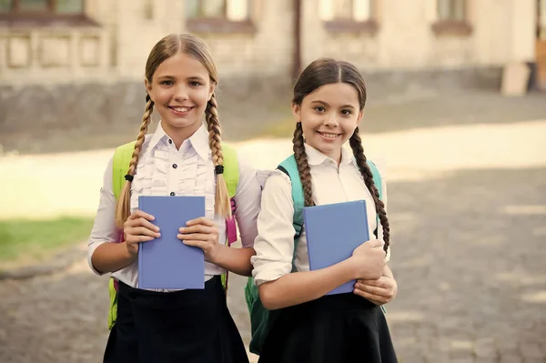 Depois da aula de literatura. Preparar para o exame. estudar juntos ao ar livre. meninas com livros e mochilas. As crianças têm caderno para anotar. infância feliz. de volta à escola. alunos adolescentes prontos para a lição — Fotografia de Stock