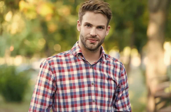 Joven hombre sin afeitar al aire libre. belleza masculina y la moda. tipo con cerdas llevar camisa a cuadros. concepto de barbería. estilo de moda casual — Foto de Stock