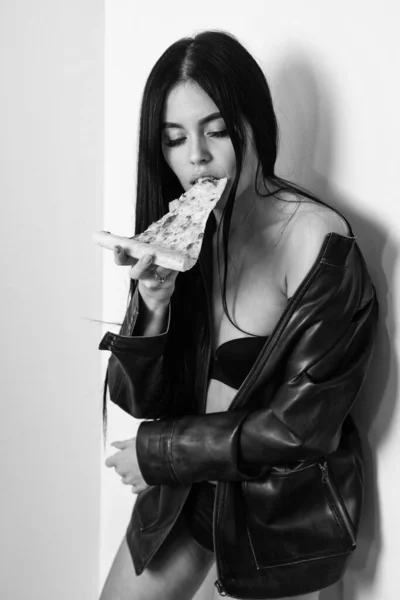 Cinsel iştah. Pizza yiyen seksi kız. Pizza teslimatı Restoran yemeği. Çekici kadın deri ceket çıplak vücut pizza yiyor. Cazip bir yemek. Baştan çıkarıcı yemek. Fast food. Diyet ve sağlıklı vücut — Stok fotoğraf