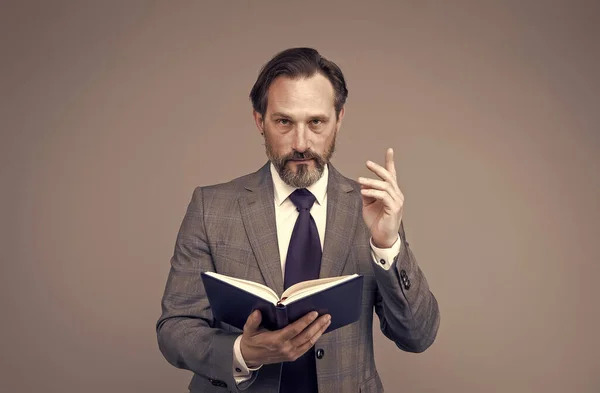 Serious man in formal suit hold open school book keeping index finger raised grey background, professor, filtro vintage — Fotografia de Stock