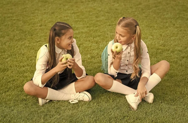 Powrót do szkoły i zdrowe odżywianie. Szczęśliwe dzieci jedzą jabłka na zielonej trawie. Zdrowa szkolna przekąska. Zdrowie szkoły. Plan diety dla szkoły podstawowej. Poprawa zdrowia i edukacji dzieci — Zdjęcie stockowe