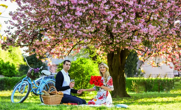 I love you. man and woman. romantic couple on picnic. love date in spring. relax under blooming sakura. couple in love. celebrating anniversary. happy family in summer park. food and drink — Foto de Stock