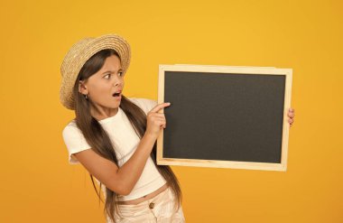 Okula dönelim. Şaşırmış bir kız hasır şapka takıyor. seyahat konsepti. Çocuklar için yaz tatili. Okul tatil fotokopi alanı. Yaz okulu eğitimi. Macera bekliyor. Okul yaz programı. çocuk moda satışı