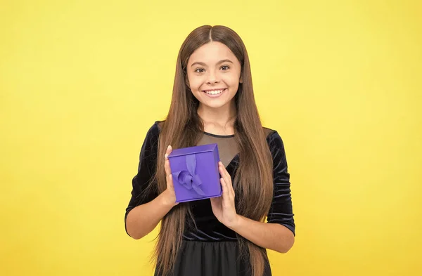 Veselá dívka dítě s dlouhými vlasy držet dárkové krabice na žlutém pozadí, kybernetické pondělí — Stock fotografie
