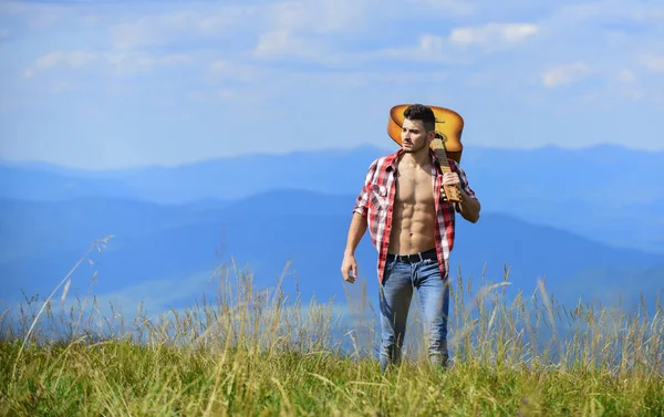 Guy hiker enjoy pure nature. Exploring nature. Beauty of nature. Best way to escape from city. Fresh mountain air. Vacation destinations. Walking alone. Man with guitar walking on top of mountain — Φωτογραφία Αρχείου